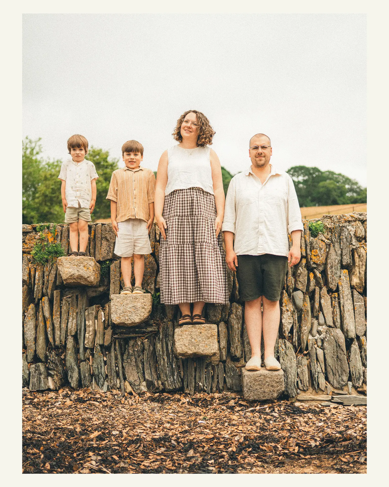 Family standing together on the stone wall at Trelissick Gardens near Truro