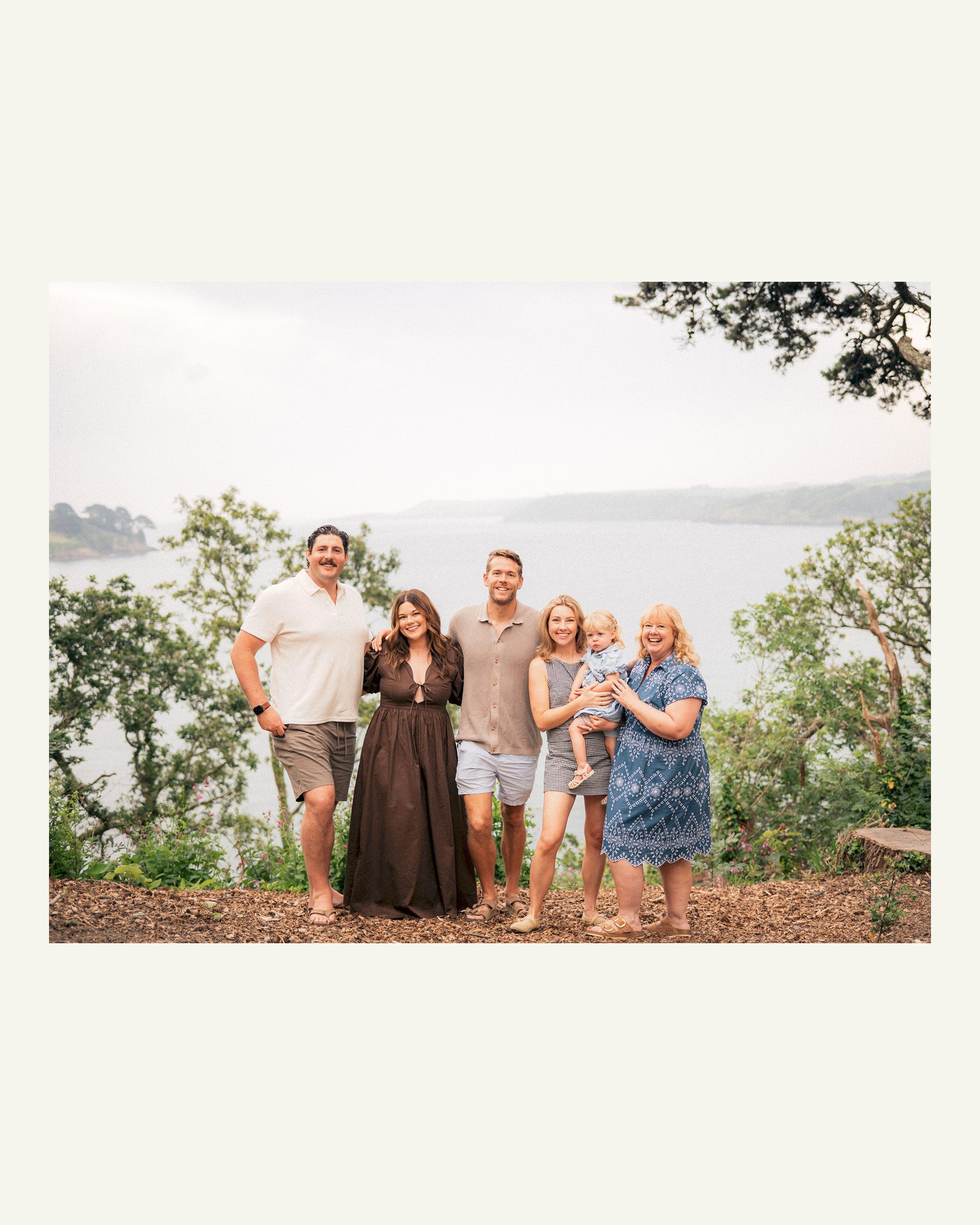 Three generations of a family standing together above the Helford River near Falmouth