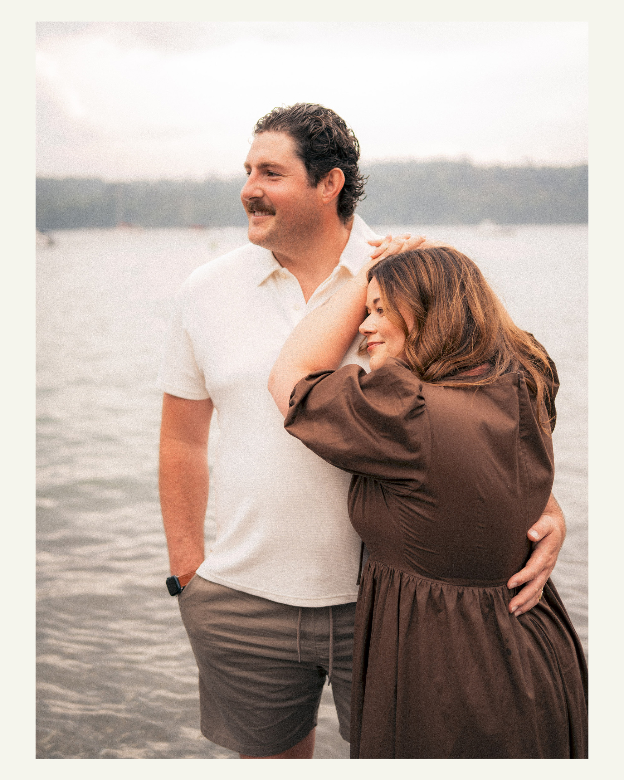 Couple sharing a quiet embrace beside the water during their Cornwall holiday photoshoot