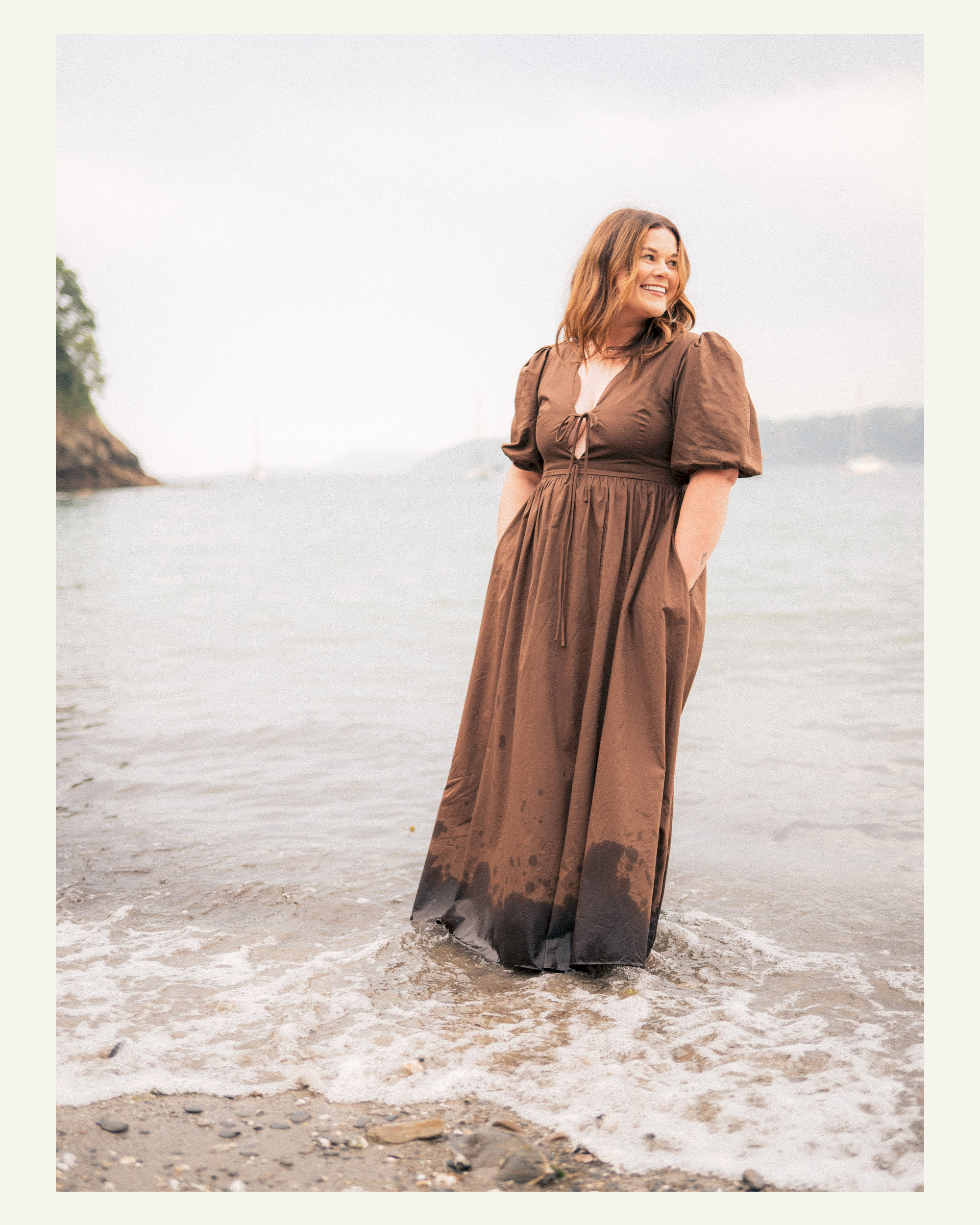 Woman smiling as she stands in the shallows at Grebe Beach near Falmouth