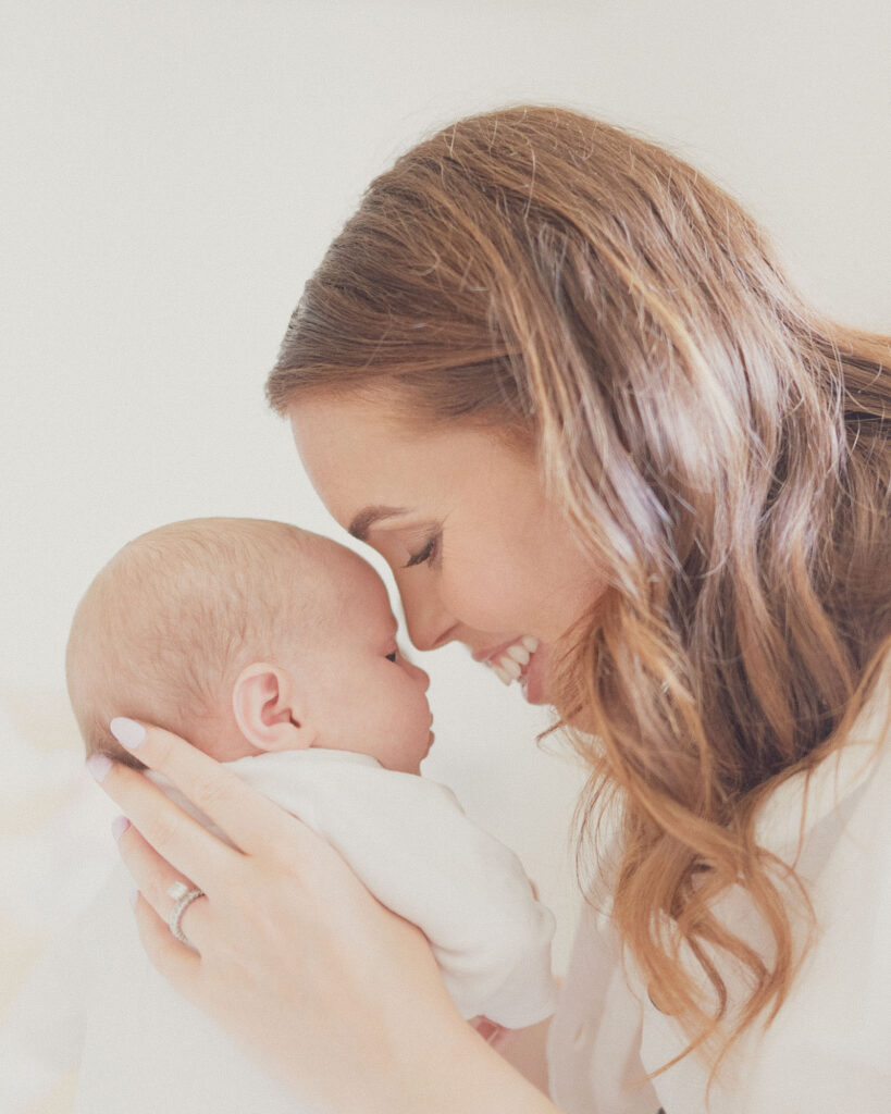 Mother smiling nose to nose with her newborn baby during an at-home photography session