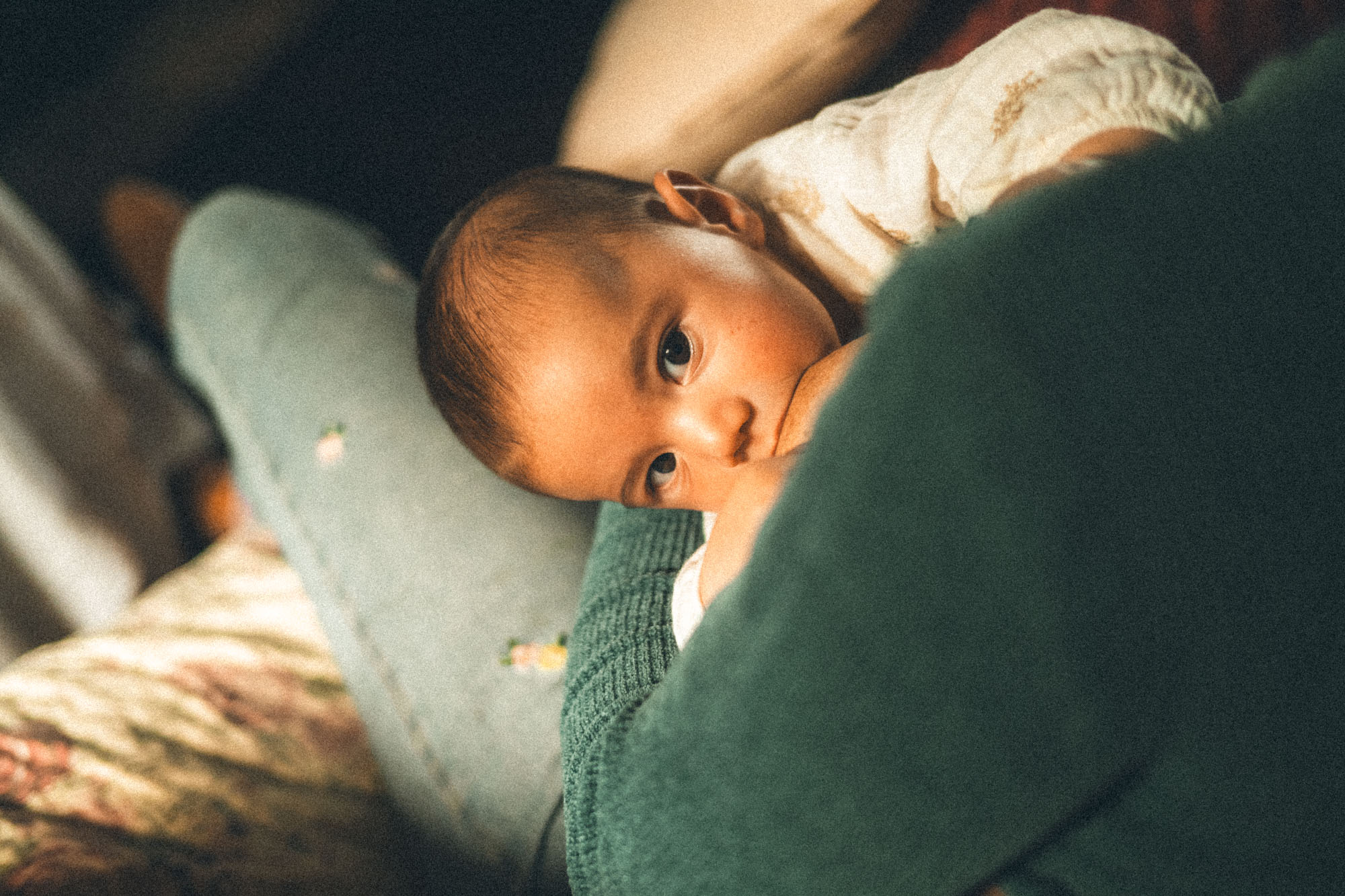 Mother breastfeeding her baby in a quiet moment at their family home in Cornwall