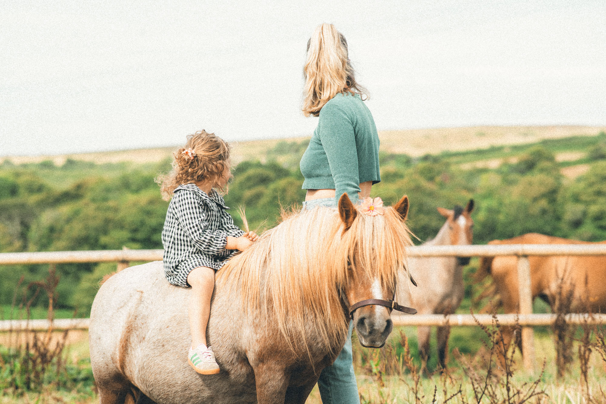 Mother and young daughter with their pony against the moorland landscape near St Ives